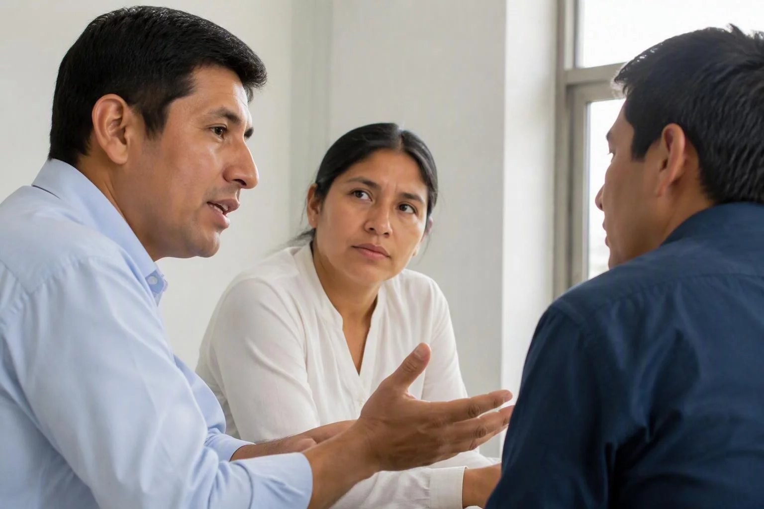 Tres personas en una sala de reuniones, una de ellas argumentando