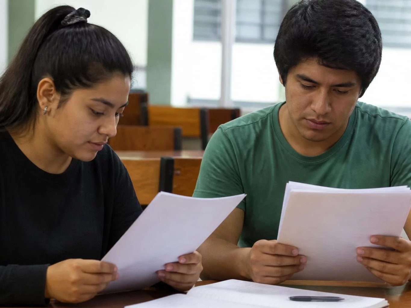 Dos asistentes leyendo juntos las hojas del caso
